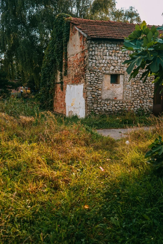 an old house in a field with lots of grass