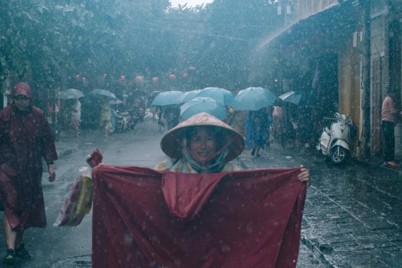 a woman wearing a large red cape and holding an umbrella