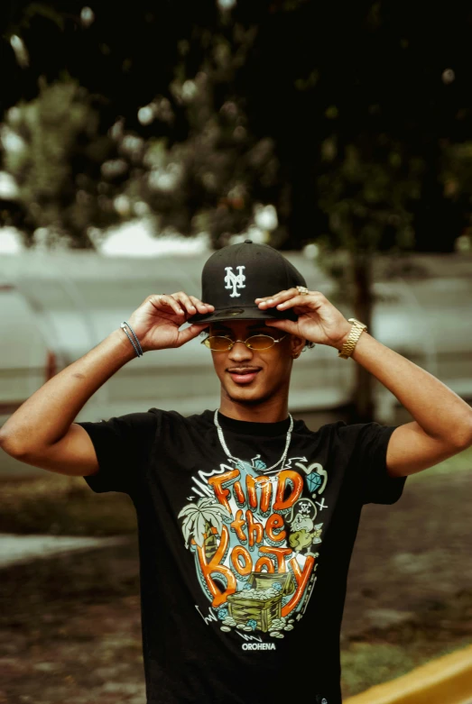 a young man holding his hat with his hands