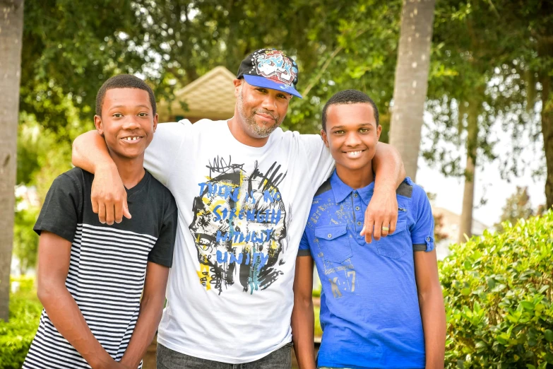 a man with his arms around three boys standing next to each other