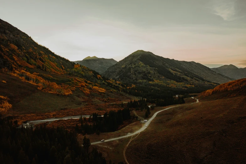 a mountain scene with a river surrounded by trees