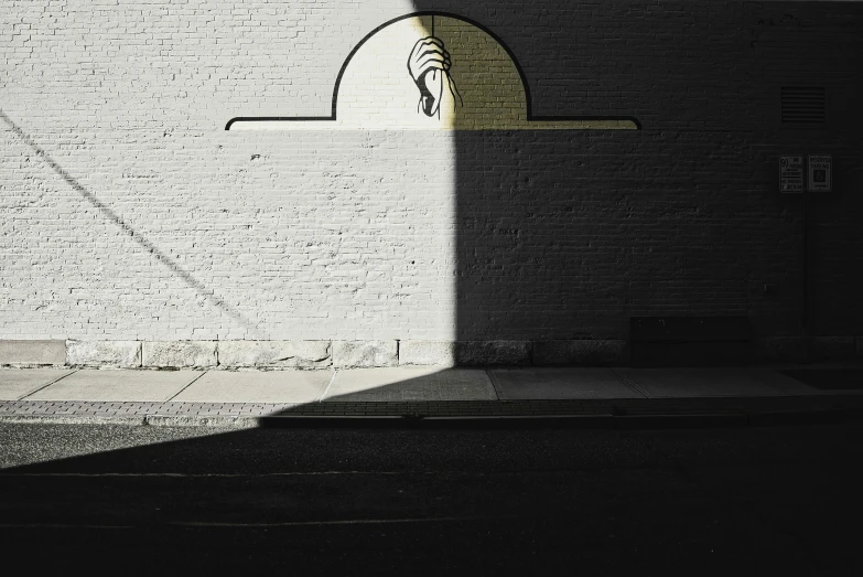 the image shows a large white brick wall and a small light that is shining on it