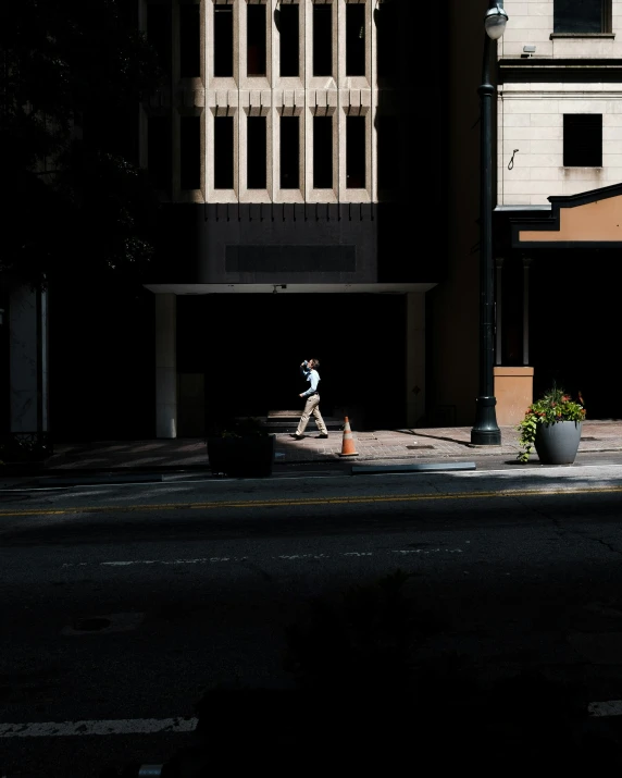 a person walking down the street under some buildings