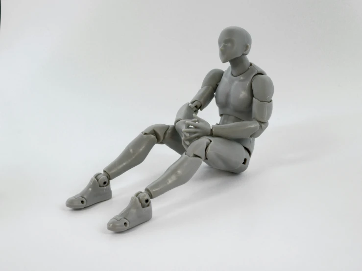 a gray plastic robot that is sitting down on its side