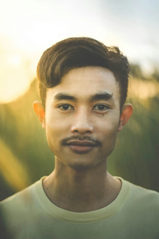 a young man standing in grass posing for a picture