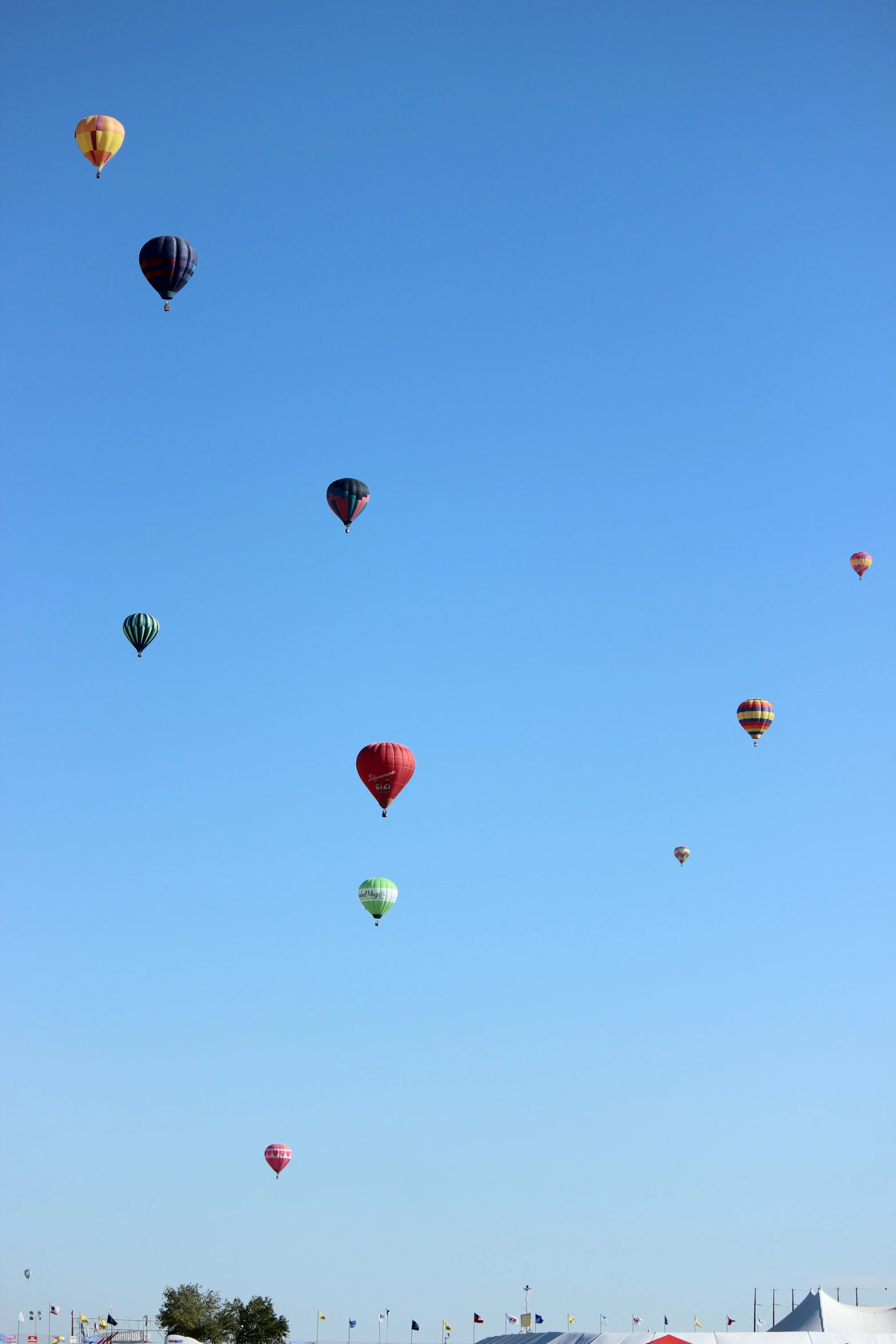  air balloons flying overhead at an outdoor event