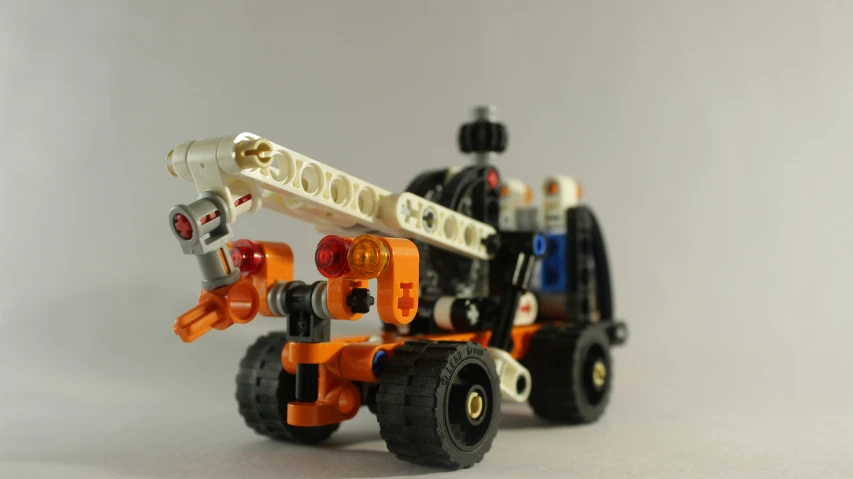 a lego fire engine with a large orange and white crane