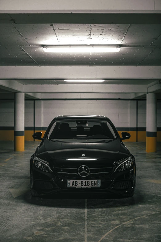 a black mercedes coupe sits in a parking garage