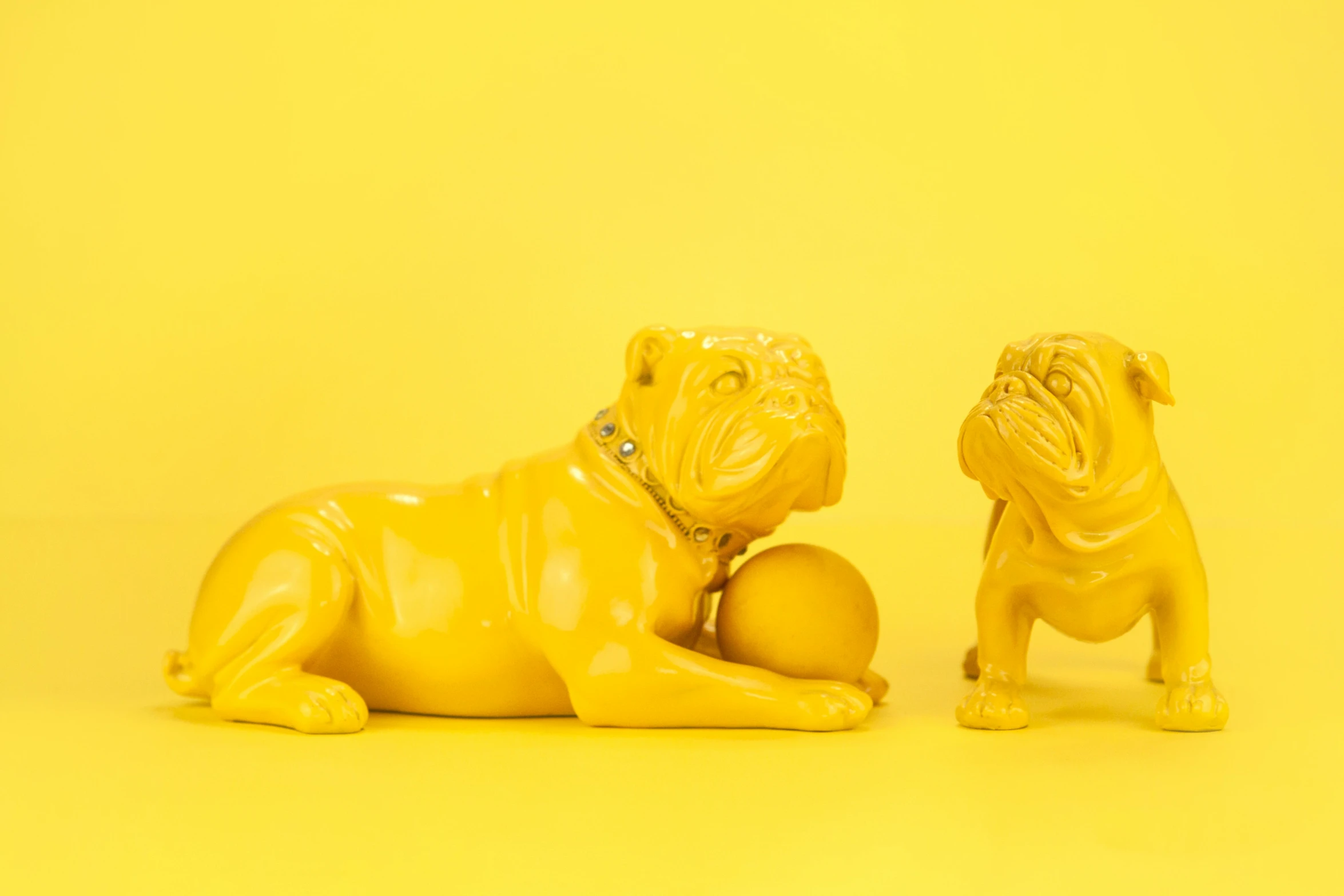 two ceramic dogs sitting together and looking up at soing