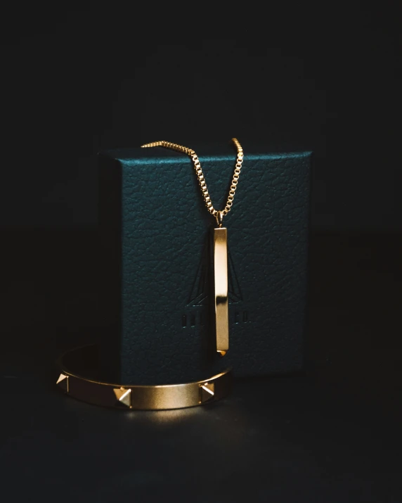 a gold necklace with an arrow on top of it