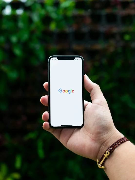 a person holding their cellphone with the google logo on it