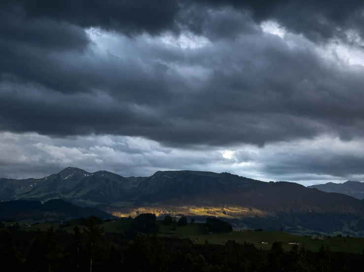 the sun shines through clouds in the mountain range