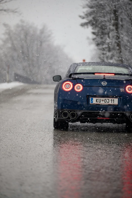 a blue car driving on a snow covered road