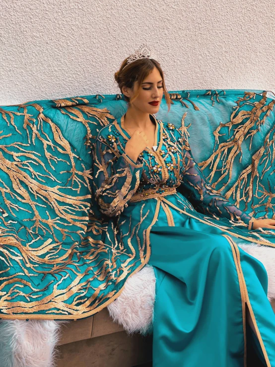 woman sitting on bench in ornately colored gown