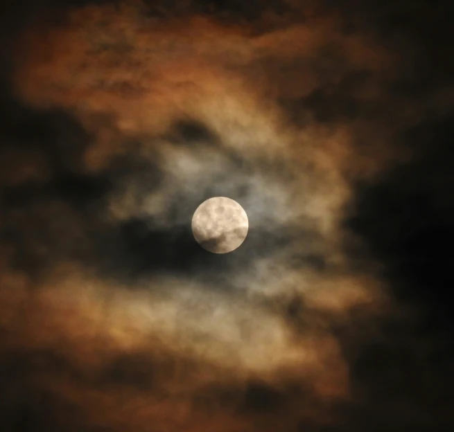 a black and white po of the moon and clouds