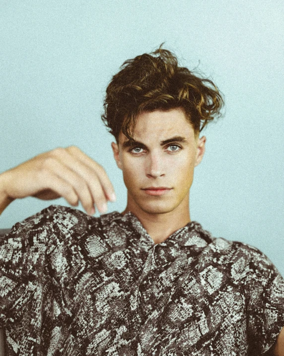 a young man with a messy haircut posing for a portrait