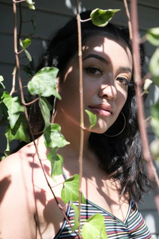 woman wearing large metal hoop earrings standing by trees