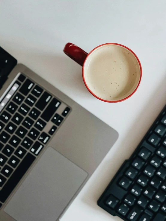 there is a cup and a laptop next to each other on the table