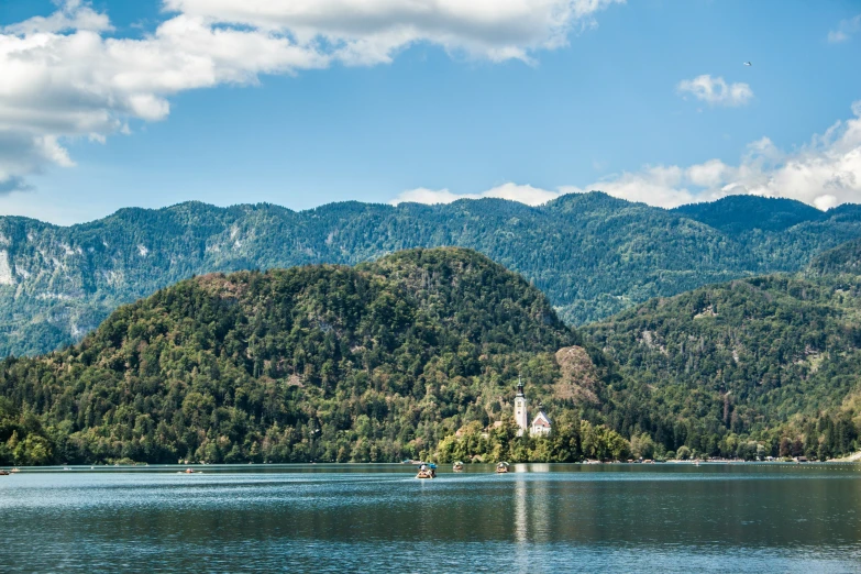 a view of mountains and a lake with trees on the shore