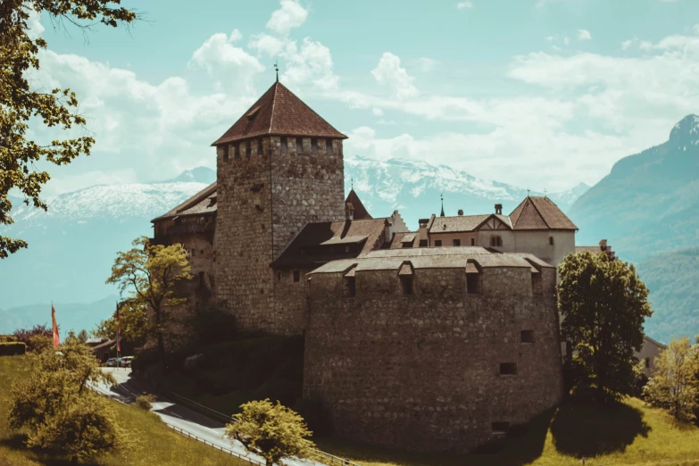 an old castle with two towers in the middle of mountains