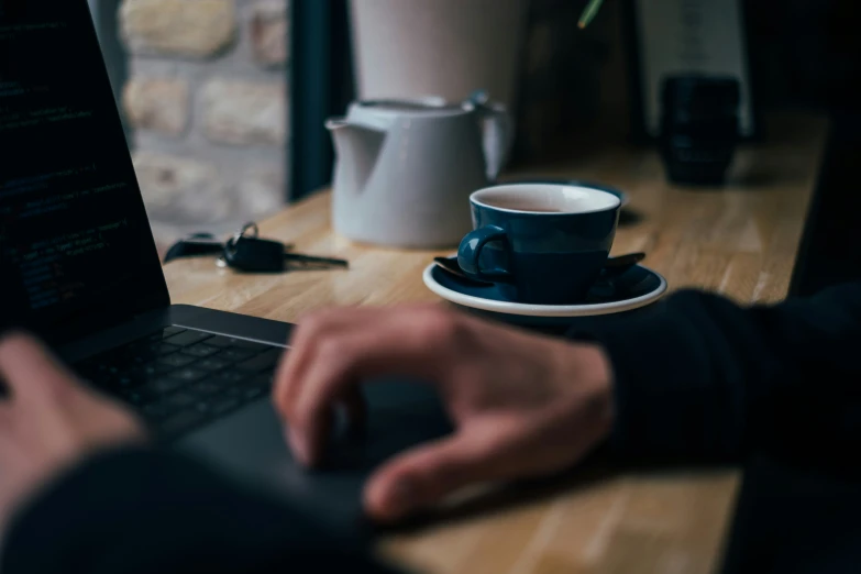 a person working on their laptop with a cup of coffee