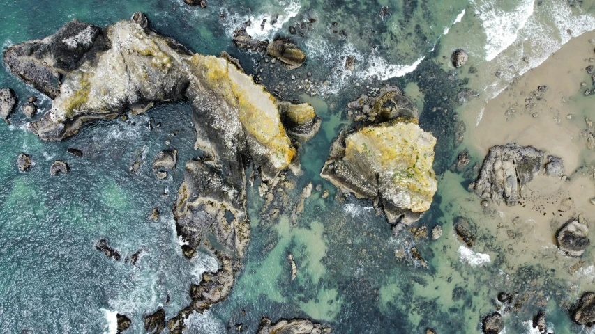 an aerial po of rocky shore next to the ocean