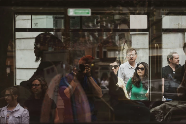 a group of people behind a window as they stare at soing