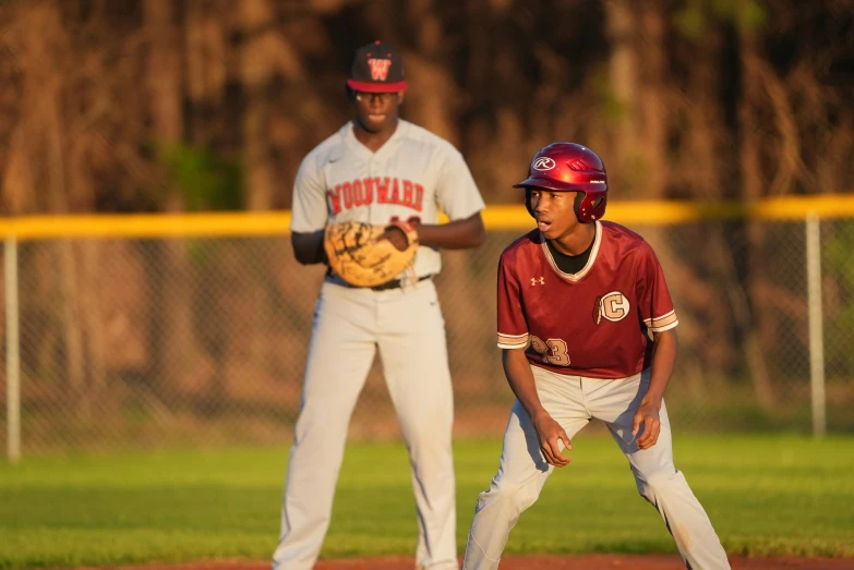 young baseball player with ball next to player during game