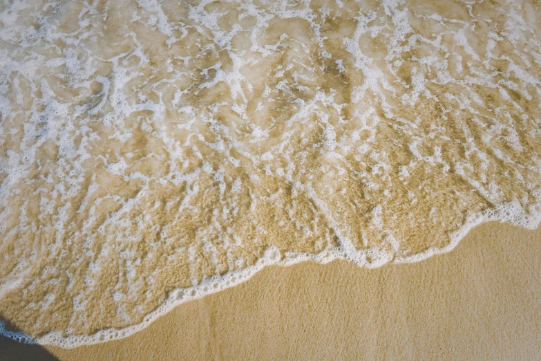 the sand on the beach and waves from the ocean