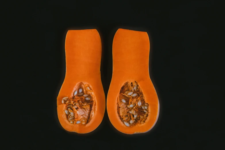 orange fruit is displayed with its seeds cut off