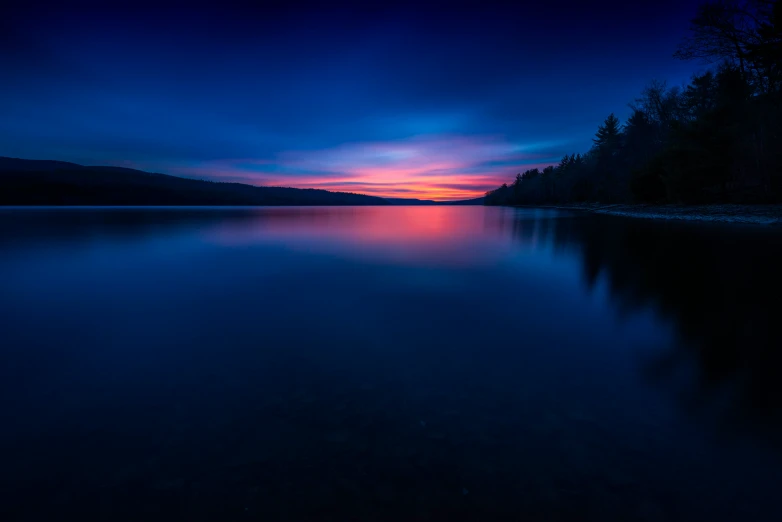 a lake at night with the sun setting on it