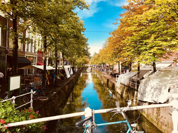 a waterway running between a city street and parked cars