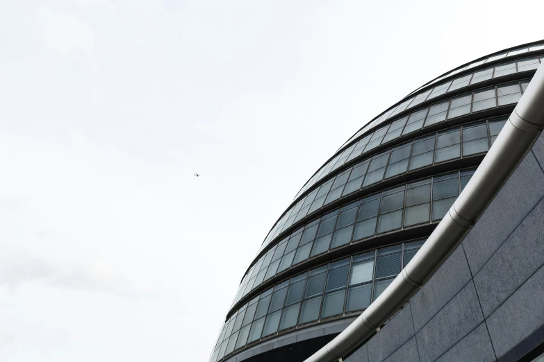 an airplane flies next to a large building with windows