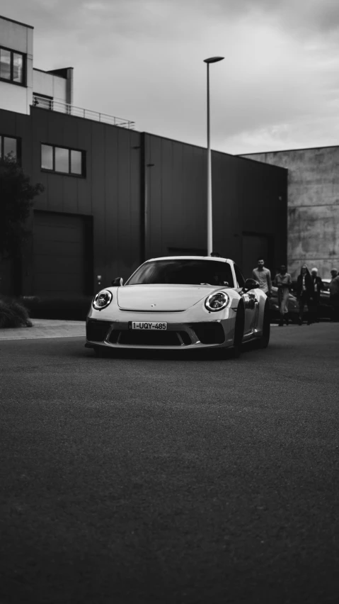 a white sports car parked in front of a building