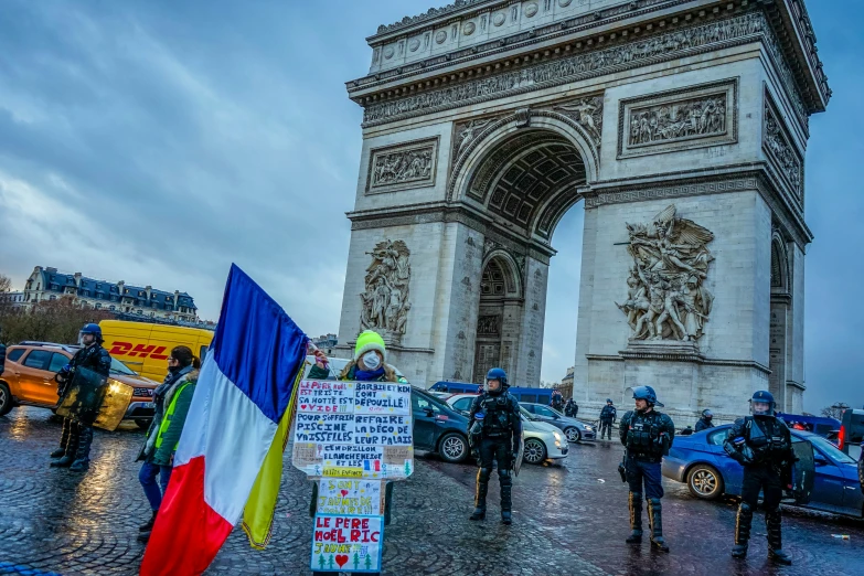 a group of police officers holding flags are standing near an arch