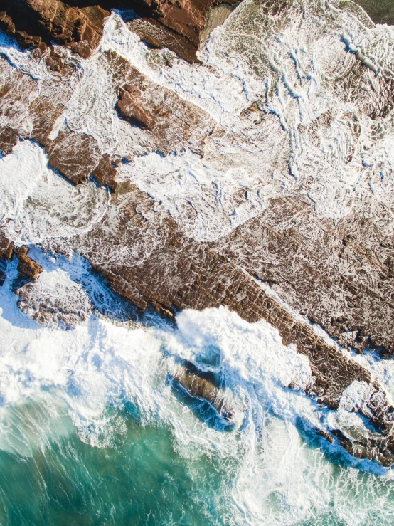 an aerial s of an ocean with snow on the top