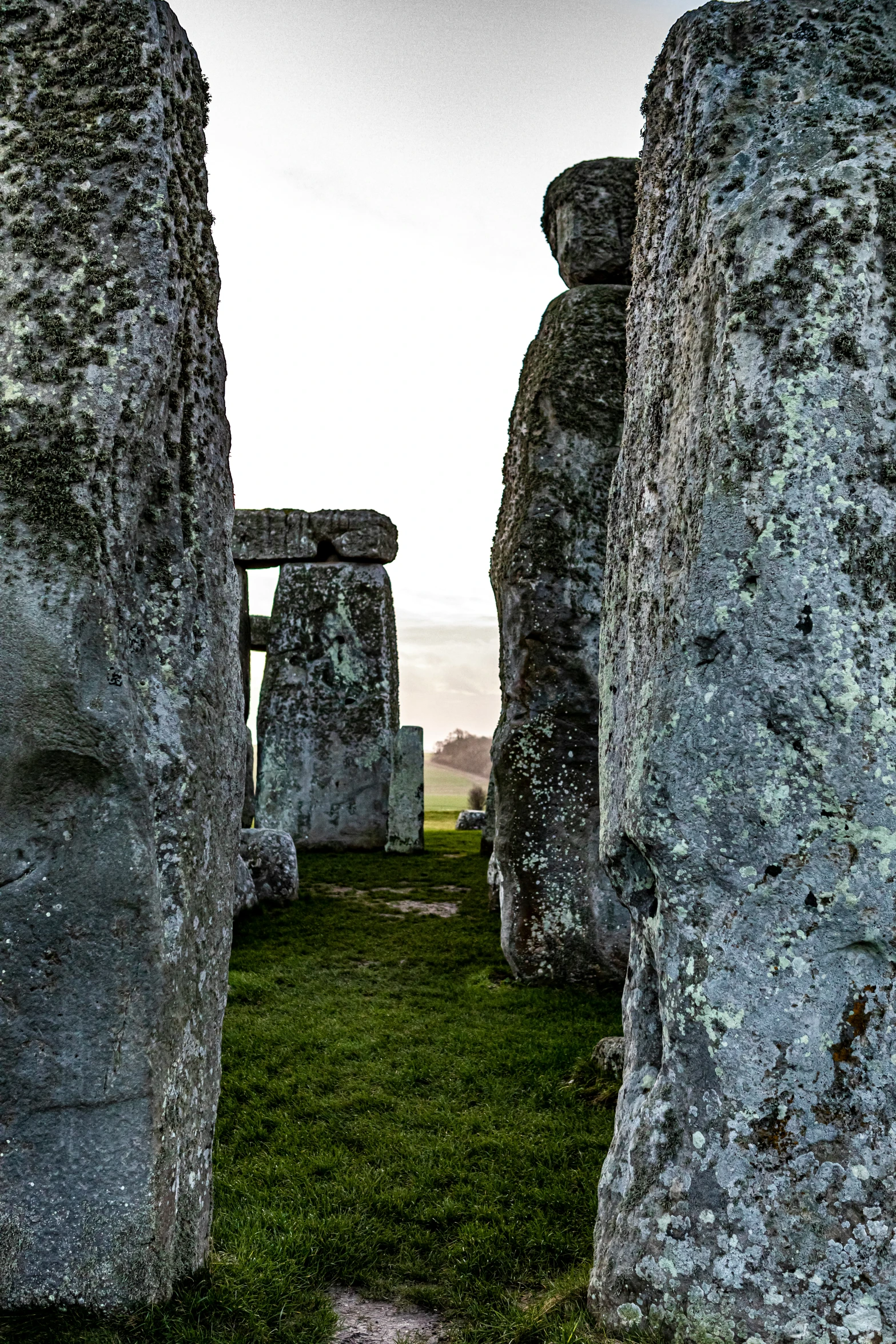 stonehenge in the distance, with a person on the grass