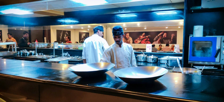 two cooks in an open kitchen with their bowls