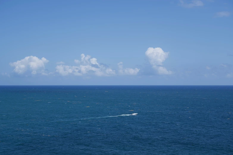 a boat floating alone in the middle of a body of water