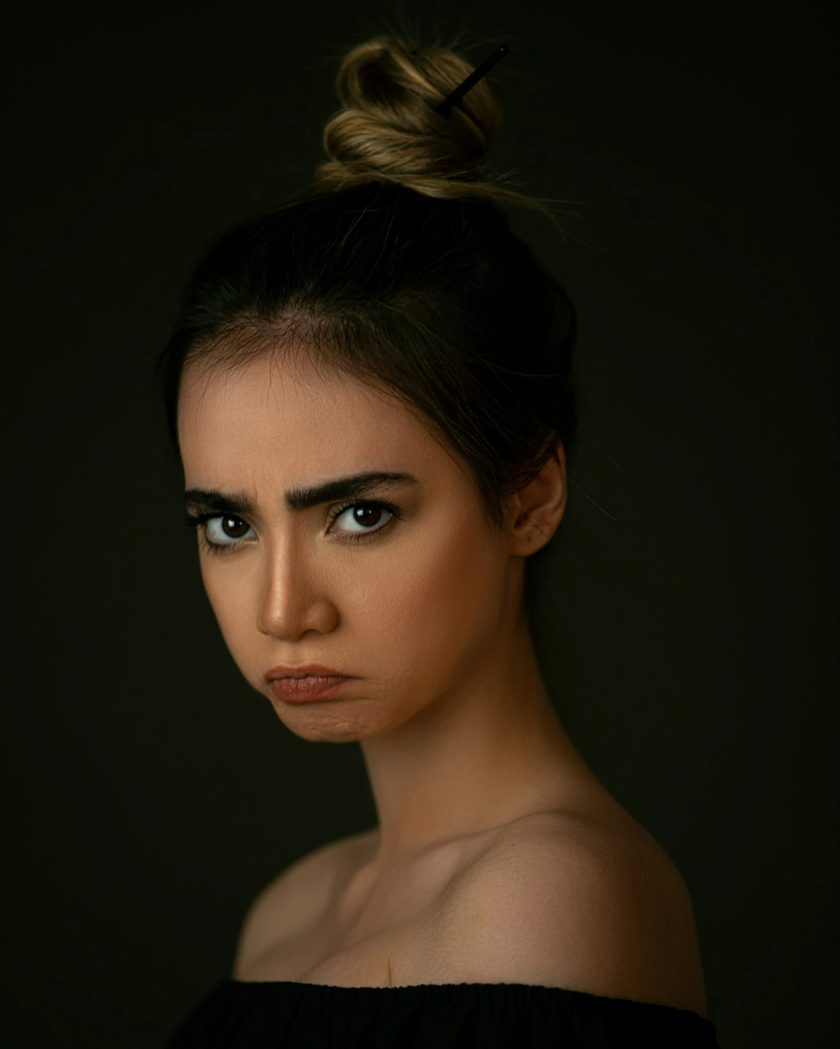 a woman with black makeup wearing a ponytail