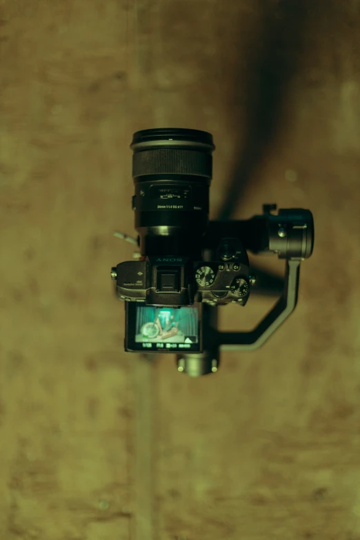 a camera with a large lens hanging off of the back of it