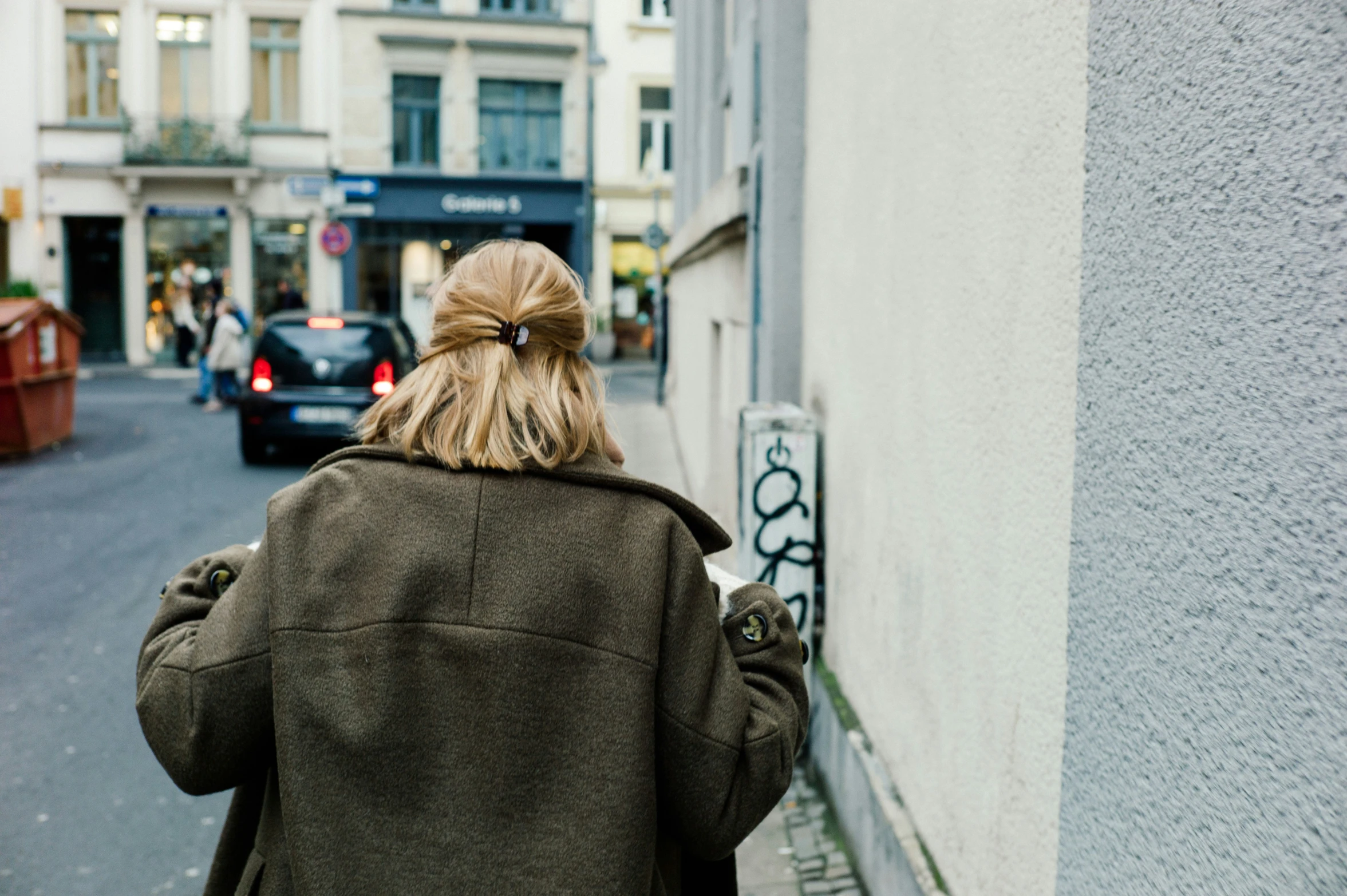 there is a woman walking up a street