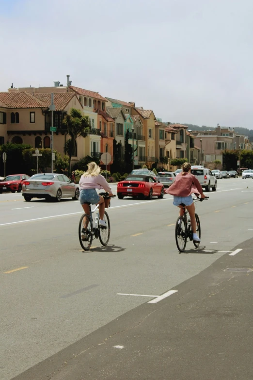 two people riding bikes in the street