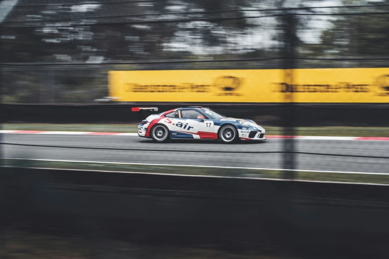 a racing car speeding on the track by some trees