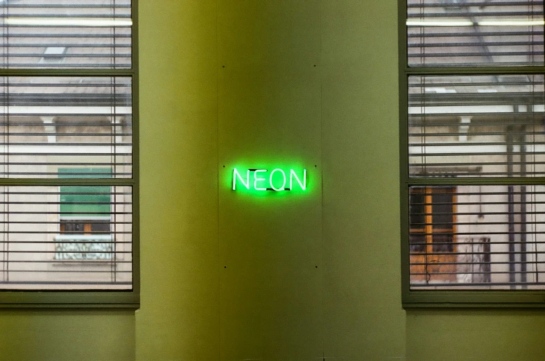 a neon sign reading neon on a green wall