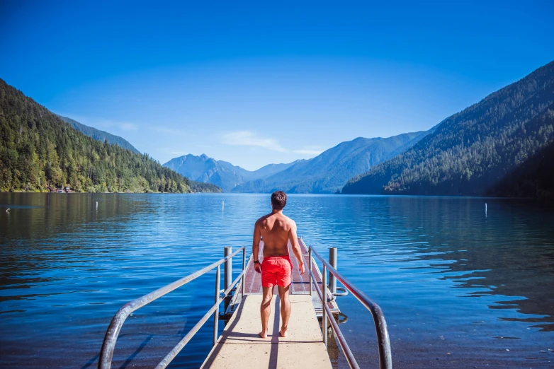 a person standing on a dock over a lake