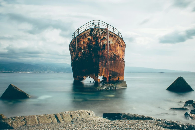 an old rusty ship anchored in the ocean