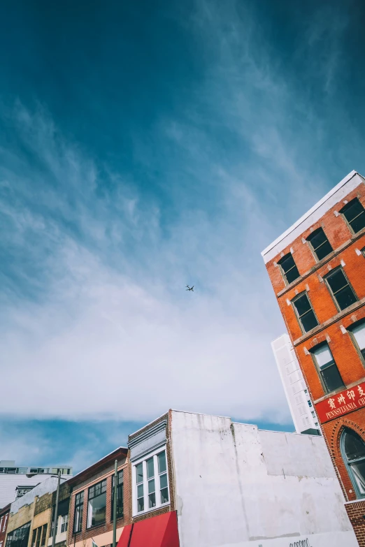 an airplane flies over two buildings in the city