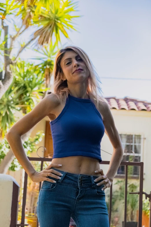 young woman posing in jean shorts, with hands on hips