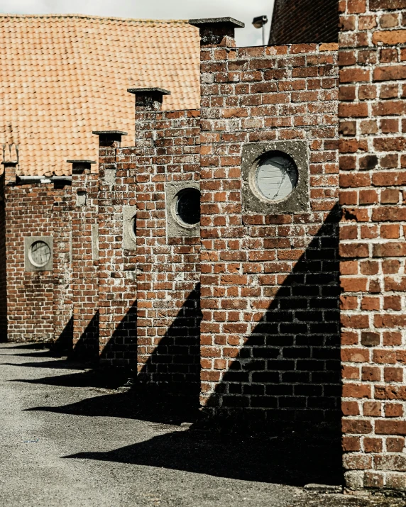 several windows are seen on the side of this brick wall